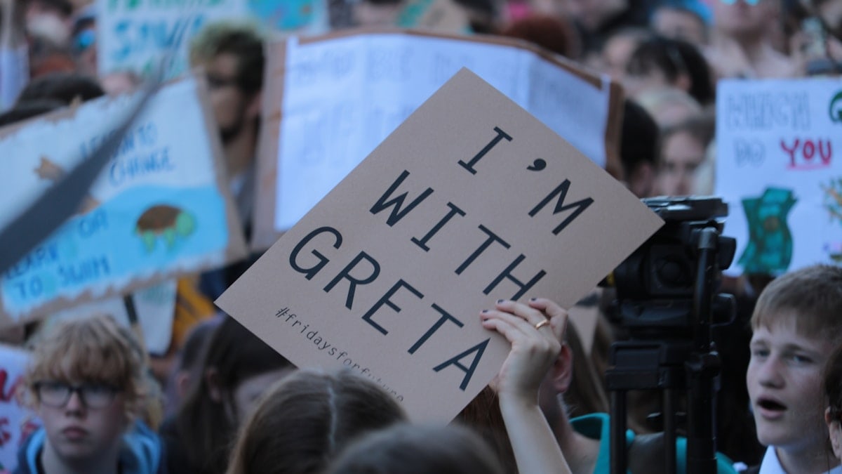 person holding I'm with Greta signage