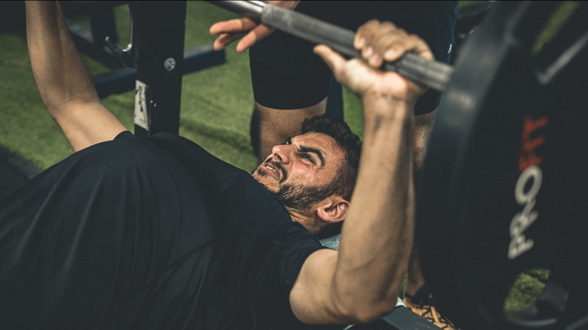 a man doing a bench press with a barbell